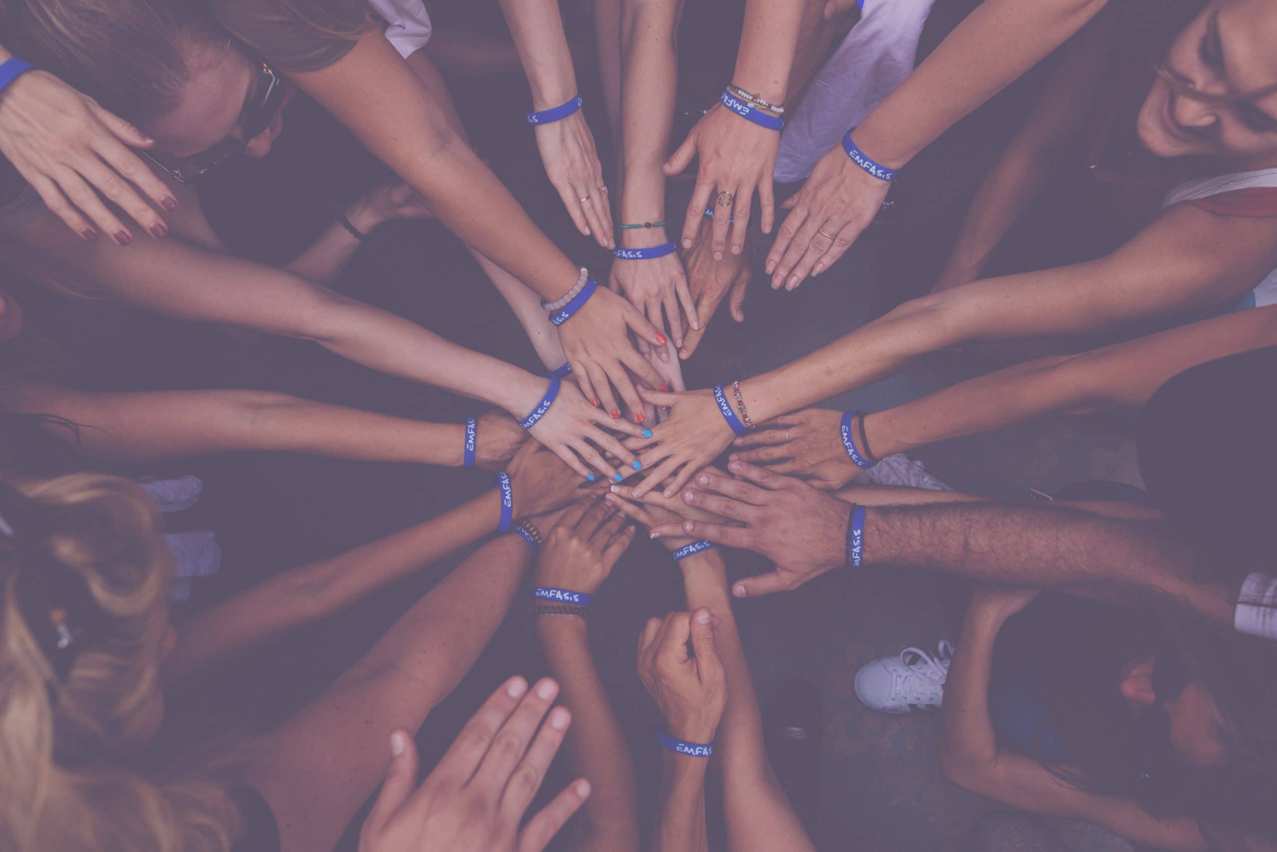 A circle of hands joining in the middle
